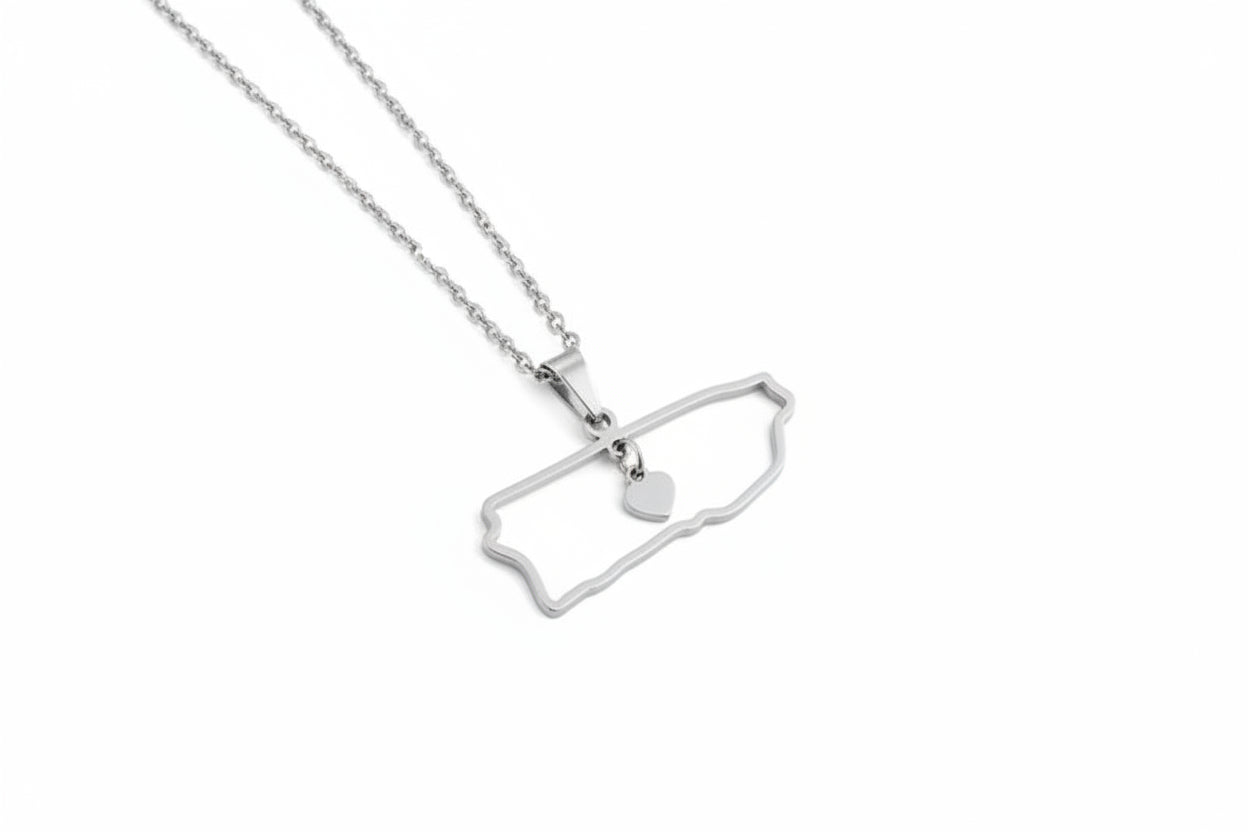Silver necklace with a pendant shaped puerto rico outline and a heart on a white background