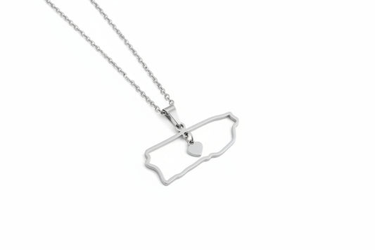 Silver necklace with a pendant shaped puerto rico outline and a heart on a white background